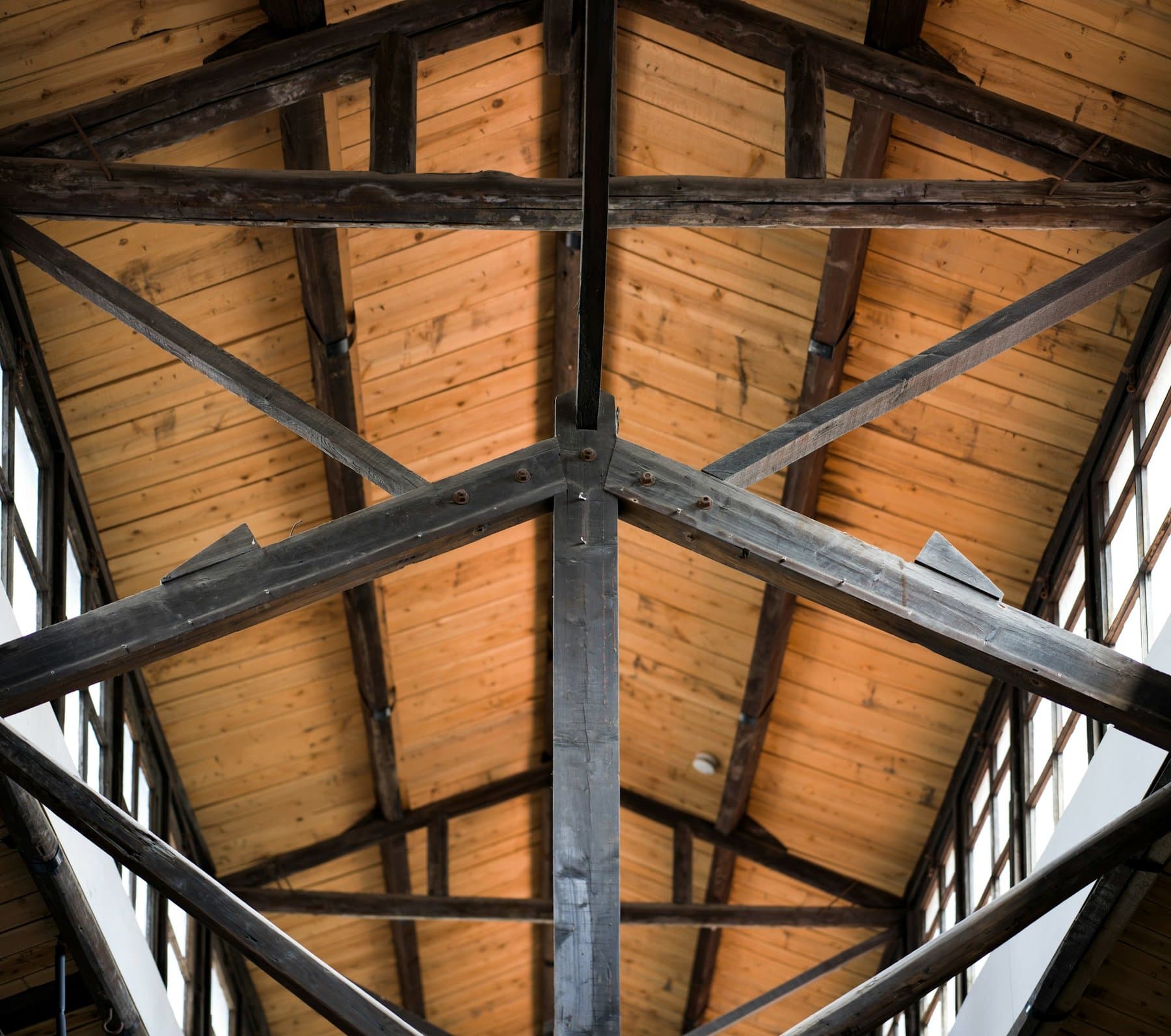 A timber roof structure under construction, light coming through the windows