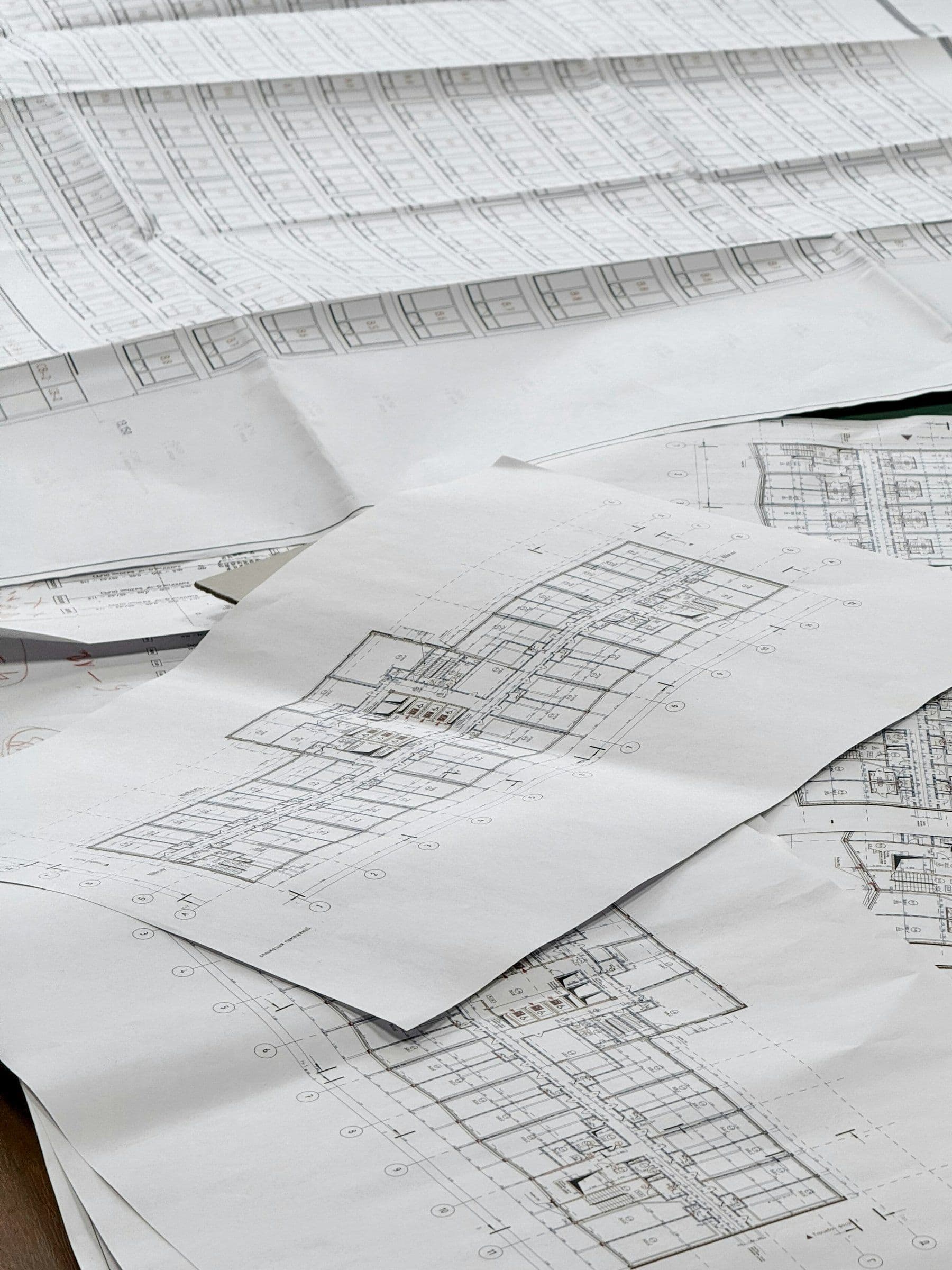 Sheets of technical construction drawings spread across a surface