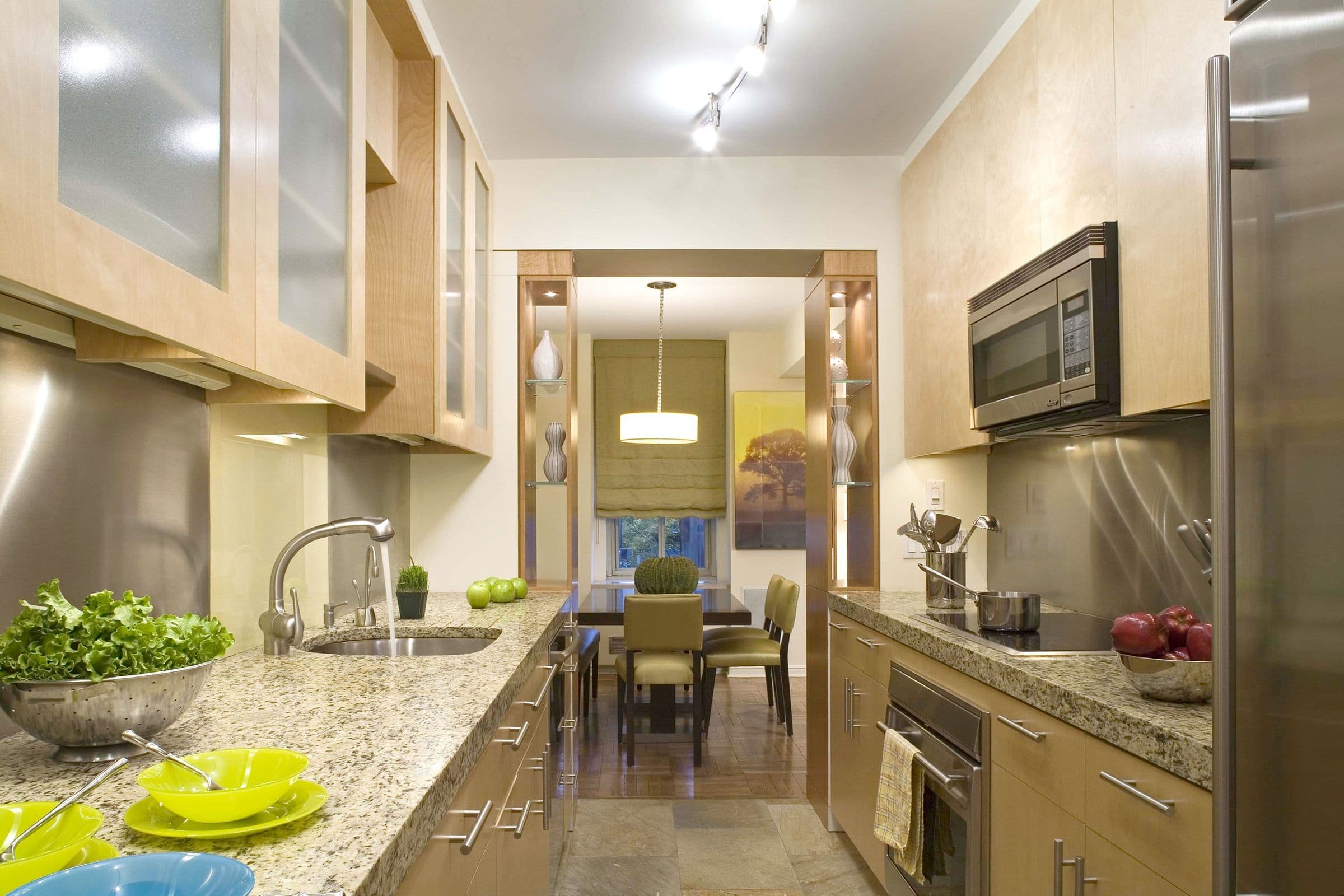 The Shaw Residence galley kitchen in maple and stainless steel, open to the dining room beyond