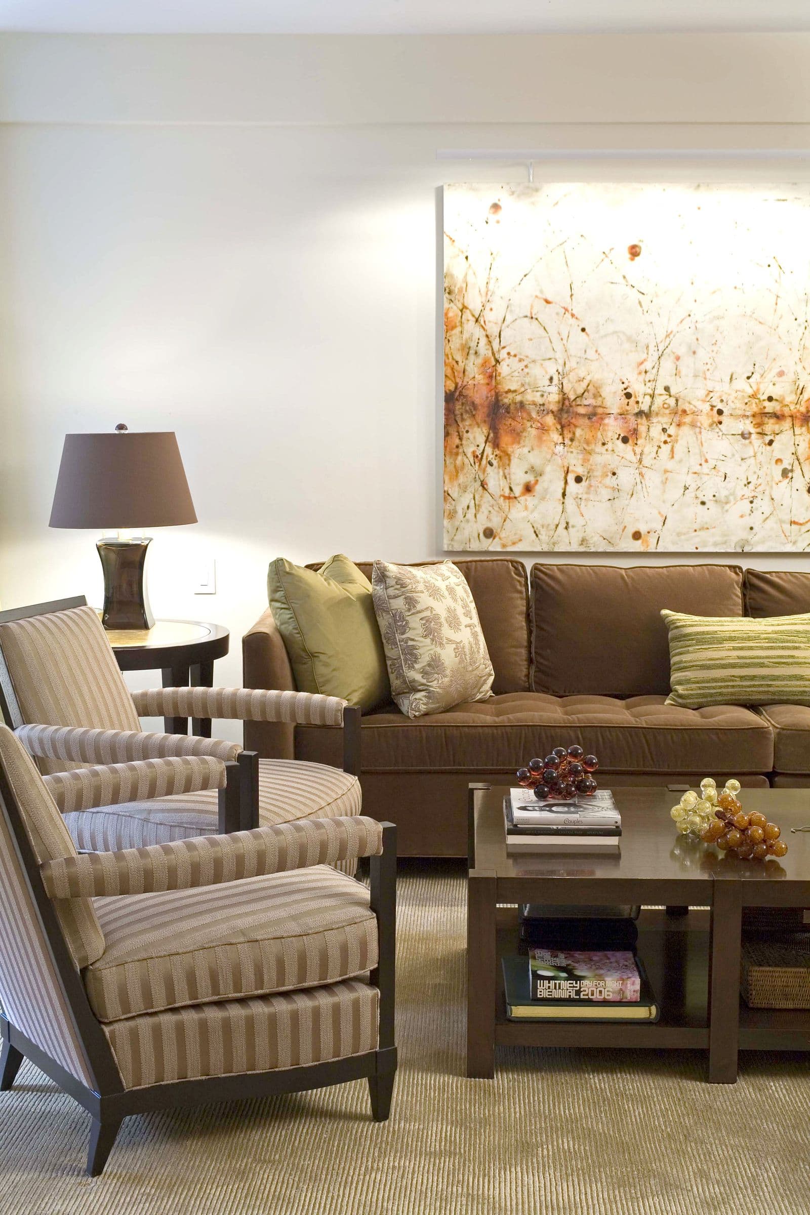 The Shaw Residence living room, a brown sofa and armchairs beneath a large abstract painting