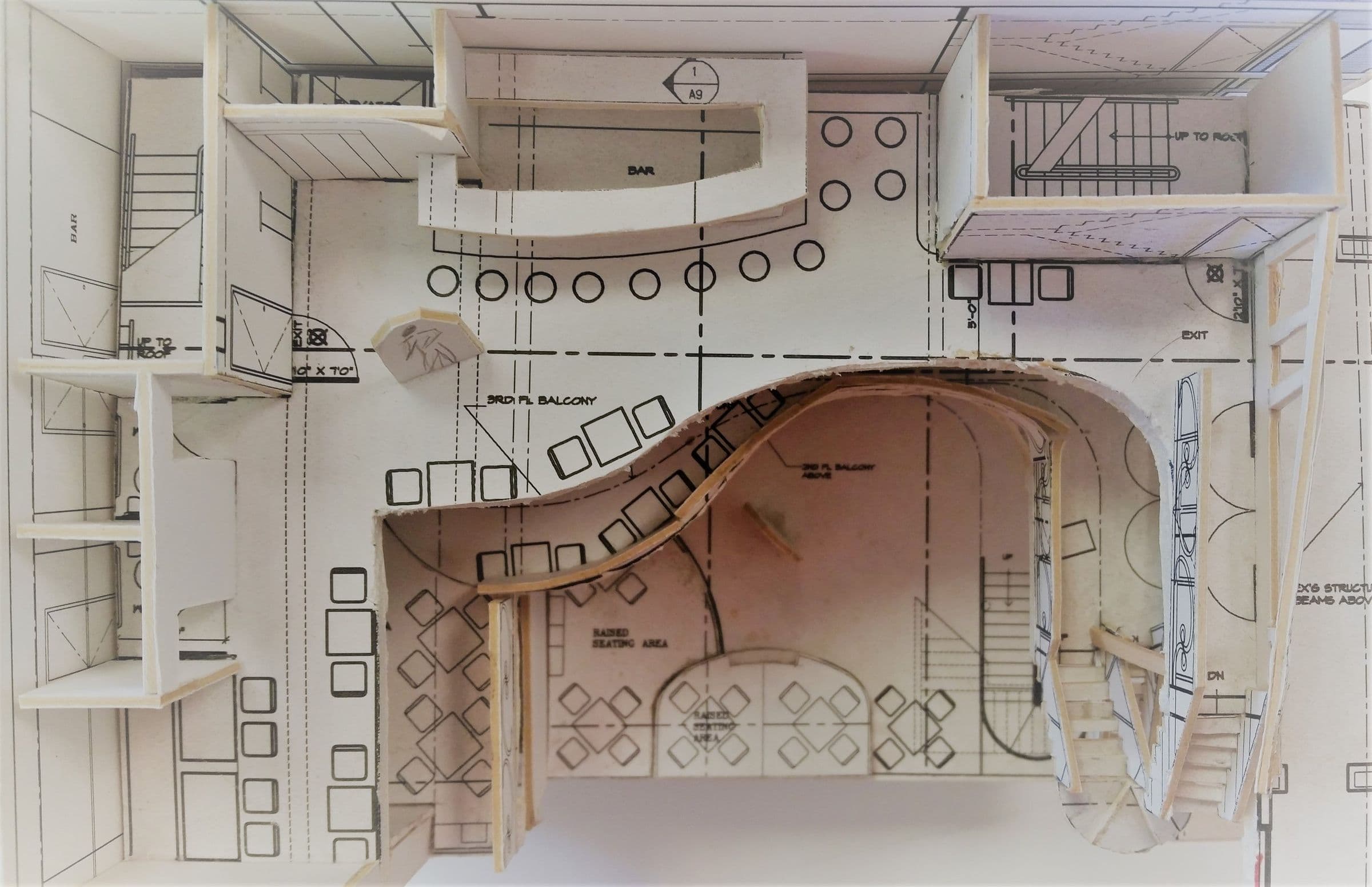A working architectural model of the Vertigo plan, tracing the curve of the mezzanine above the bar