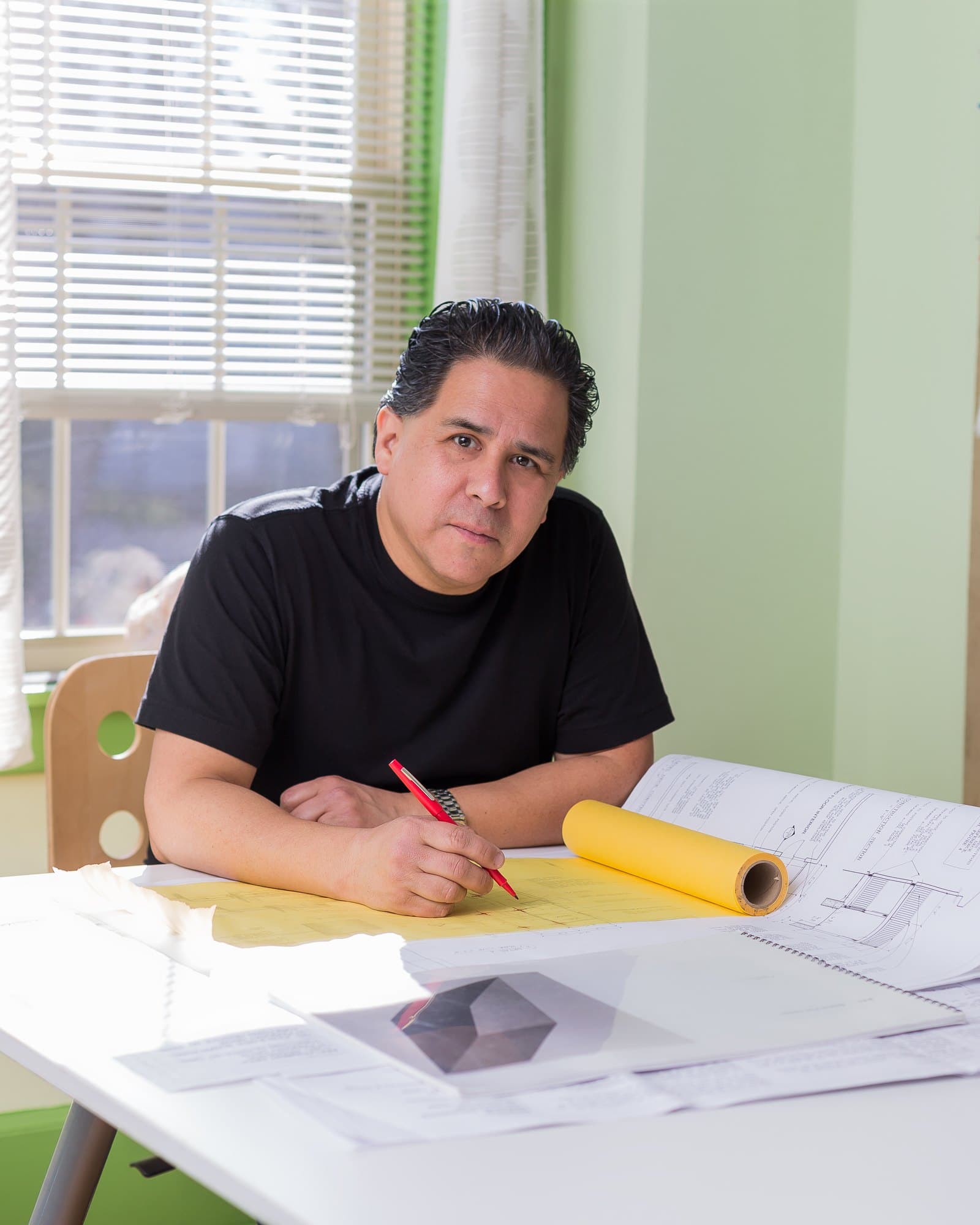 J.C. Calderón at his drafting table, working over a set of drawings