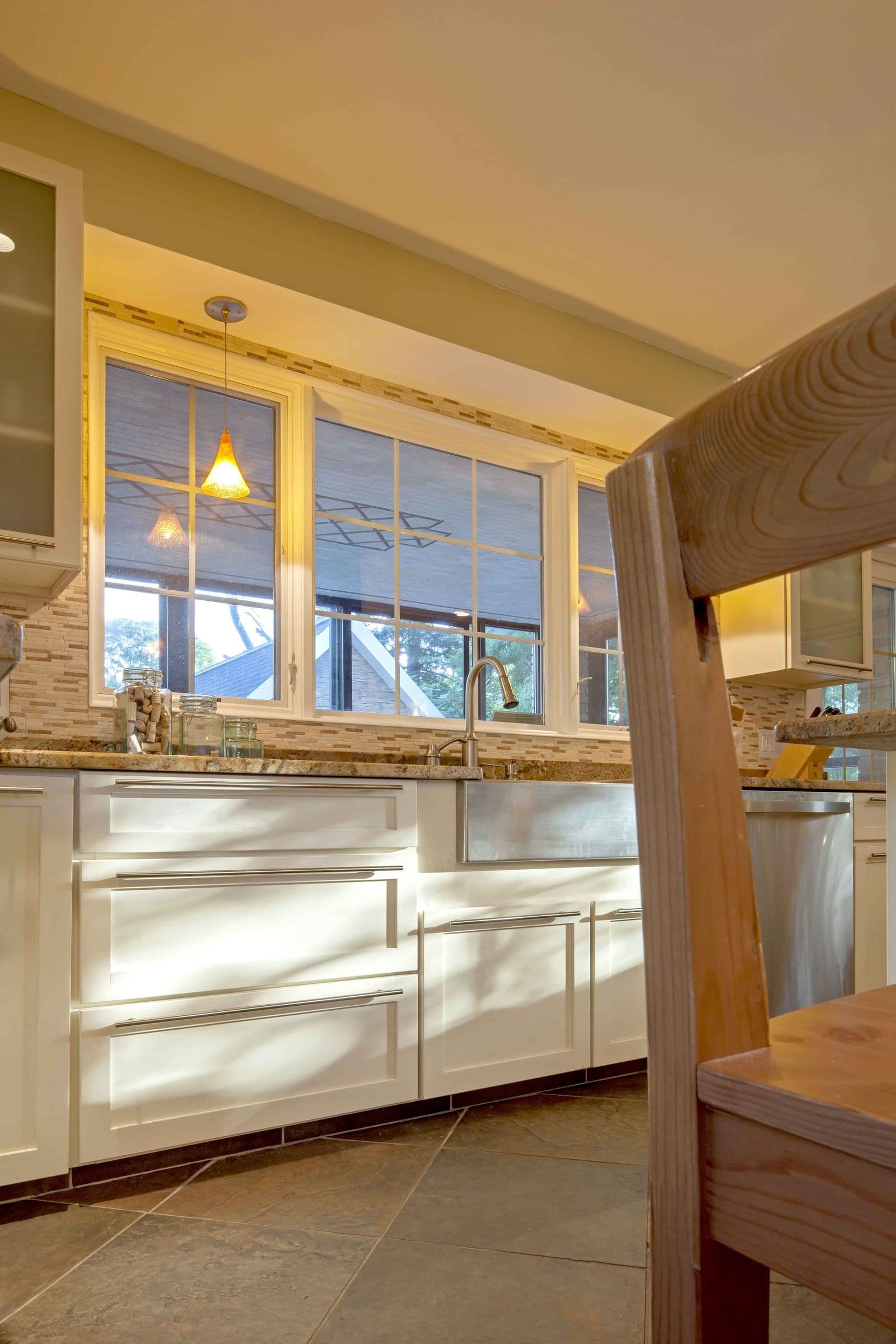 The Brión Residence kitchen sink wall, white cabinetry beneath a band of windows